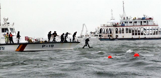 18일 오전 전남 진도군 병풍도 북쪽 해상에서 잠수대원들이 침몰한 세월호에 공기를 주입하기 위해 바다에 뛰어 들고 있다. 진도=배우한기자 bwh3140@hk.co.kr