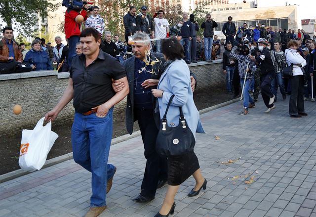 친러시아 시위대에 계란 투척하는 친 우크라이나 시위대Pro Russia protestors, right, throw eggs at pro Ukrainian activists in Donetsk, eastern Ukraine, Tuesday, April 22, 2014. U.S. Vice President Joe Biden warned Russia on Tuesday that "it's time to stop talking and start acting" to reduce tension in Ukraine, offering a show of support for the besieged nation as an international agreement aimed at stemming its ongoing crisis appeared in doubt. (AP Photo/Sergei Grits)