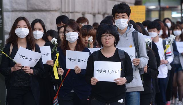 검은 옷을 입고 마스크를 쓴 100여명이 4월 30일 오후 서울광장에서 침묵 행진을 하고 있다. 이들은 세월호 침몰 당시 선내에 방송된 "가만히 있으라"는 문구를 적은 피켓과 노란 리본을 맨 국화를 든 모습으로 사고 책임자들을 질타하고 희생자들의 넋을 기렸다. 류효진기자 jsknight@hk.co.kr