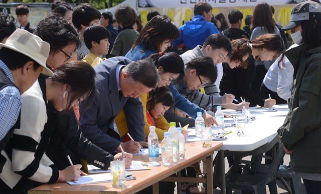 세월호 침몰 사고 20일째인 5일 오전 경기도 안산시 단원구 초지동 화랑유원지 내 정부 공식 합동분향소 출구에 유족들이 희생자·실종자 조기 수습과 사고 진상 규명을 위해 특검과 청문회를 열자는 서명운동을 벌여 시민들이 줄을 지어 서명하고 있다. 류효진기자 jsknight@hk.co.kr