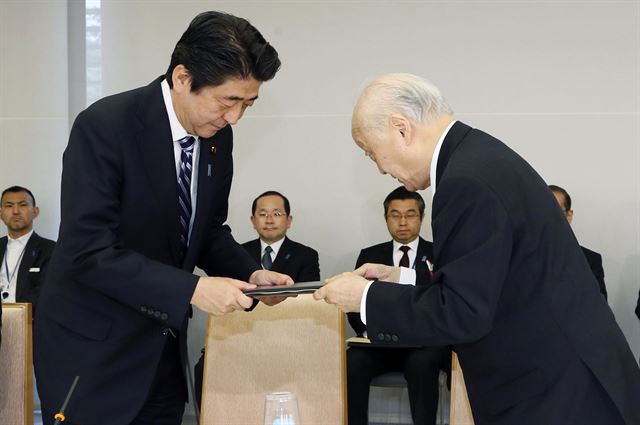 아베 신조 일본 총리가 15일 총리 자문기구인 '안보법제간담회'의 좌장인 야나이 순지 전 주미대사에게서 헌법 해석 변경을 요청하는 보고서를 건네받고 있다. <저작권자 ⓒ 1980-2014 ㈜연합뉴스. 무단 전재 재배포 금지.>