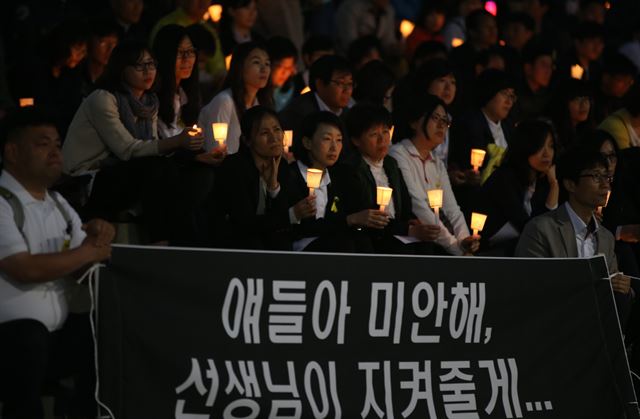 세월호 사고 30일째이자 스승의 날인 15일 오후 경기도 안산시 단원구 고잔동 문화의 광장에서 안산지역 교사와 시민들이 세월호 희생자를 추모하고 진상규명을 촉구하는 촛불을 들고 있다. <연합뉴스>