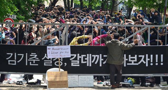 16일 오후 경기 안성시 금수원 입구를 가로막고 있는 기독교복음침례회 신도들이 스트레칭을 하고 있다. 정문에는 1991년 오대양 사건 당시 법무부 장관이었던 김기춘 대통령 비서실장을 겨냥해 ‘김기춘 실장, 갈 데까지 가보자’라고 적힌 현수막이 걸려 있다. <뉴시스>