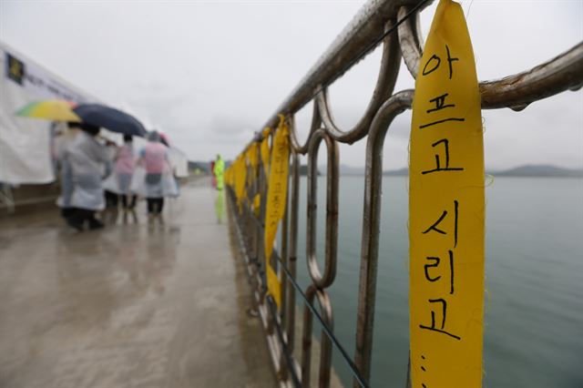 세월호가 침몰한 지 35일째가 된 20일 비가 내리는 전남 진도 팽목항의 방파제 난간에 '아프고 시리고'라고 쓴 띠가 걸려 있다. 진도=연합뉴스