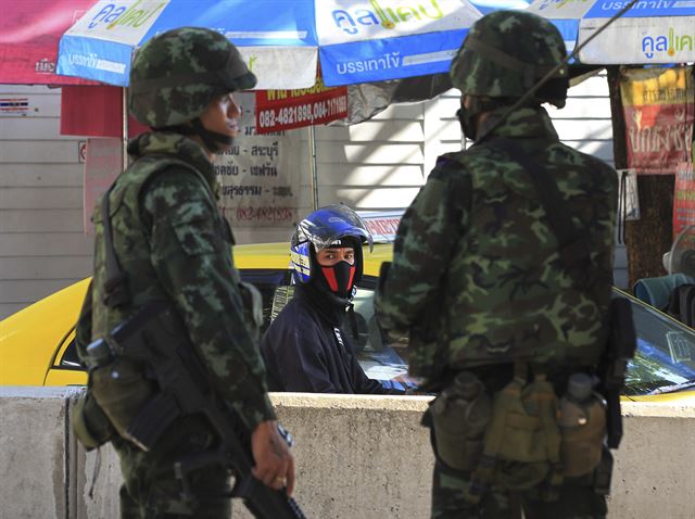 (AP=연합뉴스) 태국군이 쿠데타를 선언한 22일(현지시간) 수도 방콕에서 계엄군들이 거리를 지키고 서 있다. 계엄사령관인 프라윳 찻-오차 육군참모총장은 이날 대국민 연설을 통해 쿠데타를 선언했다.