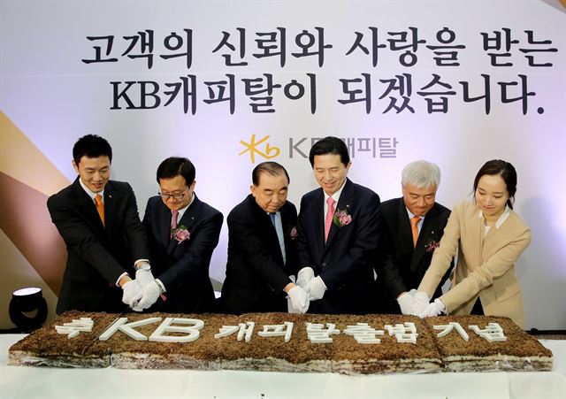 임영록 KB금융그룹 회장이 3월 그룹의 11번째 계열사가 된 KB캐피탈 출범 기념식에서 축하 떡을 자르고 있다. KB금융그룹 제공