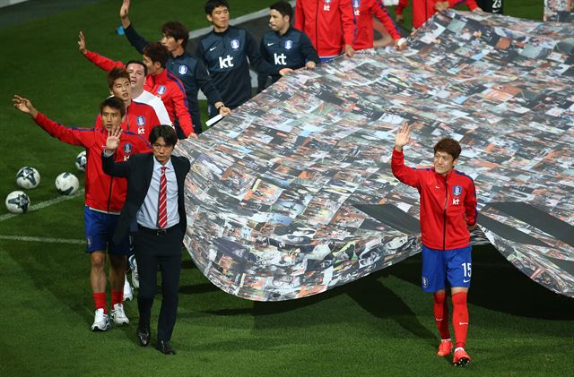 28일 오후 서울 마포구 서울월드컵경기장에서 열린 한국축구대표팀의 출정식에서 홍명보 감독 및 대표팀 선수들이 대형태극기를 들고 경기장을 돌며 팬들을 향해 인사하고 있다. 연합뉴스