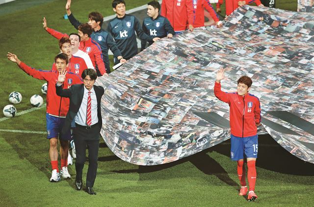 28일 오후 서울 마포구 서울월드컵경기장에서 열린 한국축구대표팀의 출정식에서 홍명보 감독 및 대표팀 선수들이 대형태극기를 들고 경기장을 돌며 팬들을 향해 인사하고 있다. 연합뉴스