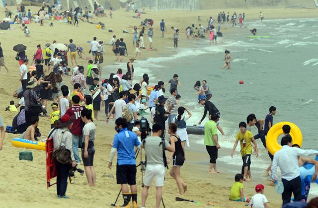 1일 개장한 부산 해운대 해수욕장에 시민과 관광객 3만여명이 몰려 물놀이를 즐기고 있다. 부산=뉴시스·연합뉴스