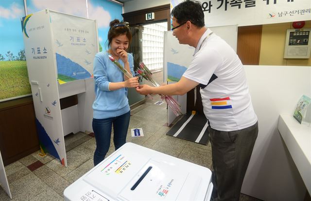 제6회 전국동시지방선거일인 4일 오후 대구 남구 대명6동 제1투표소에서 대구 남구선관위원회 관계자가 투표를 마친 한 시민에게 감사의 뜻으로 장미꽃을 선물하고 있다. 뉴시스