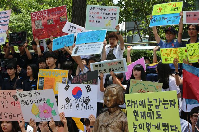 한국정신대문제대책협의회 주최로 4일 오후 서울 중학동 일본대사관 앞에서 열린 제1129차 일본군 위안부 문제 해결을 위한 정기 수요시위에서 참가 학생들이 위안부 소녀상 주변으로 일본의 위안부 문제 사과를 요구하는 손팻말을 들고 있다. 연합뉴스