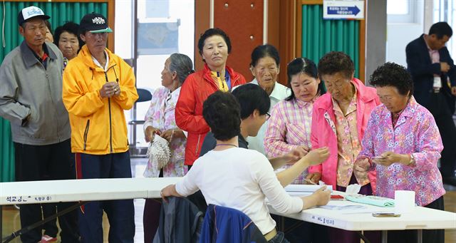 제6회 동시지방선거일인 4일 오전 전남 진도군 임회면 제1투표소가 마련된 진도국악고등학교 체육관에서 주민들이 선거인명부를 확인하고 있다. 연합뉴스