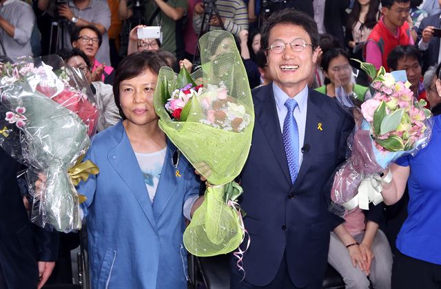 조희연 서울시교육감 후보가 5일 오전 서울 종로구 새문안로 자신의 선거 캠프에서 당선이 확실시되자 부인과 함께 꽃다발을 받고 환하게 웃고 있다. 연합뉴스