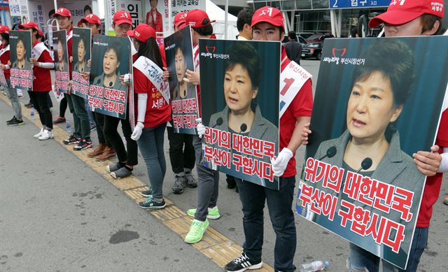 서병수 새누리당 부산시장 후보가 1일 오후 부산역 광장에서 대규모 유세를 벌인 가운데 선거운동원들이 박근혜 대통령이 눈물 흘리는 사진과 '위기의 대한민국, 부산이 구합시다'라는 문구가 적힌 피켓을 들고 있다. 연합뉴스