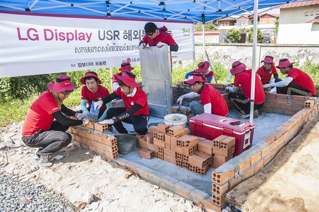 LG디스플레이 직원들이 캄보디아 프놈펜에서 안과클리닉으로 사용할 건물을 지어 주는 봉사활동을 하고 있다. LGD 제공