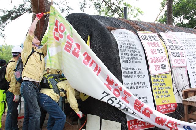 경남 밀양시청 직원들이 11일 오전 경남 밀양시 부북면 장동마을 129번 송전탑 입구 진입로에 설치된 송전탑 반대 주민들이 설치한 비닐하우스형 움막을 철거하고 있다. 이에 앞서 경찰은 비닐하우스 움막에서 농성중인 주민 10여명을 제압해 끌어냈다. 연합뉴스