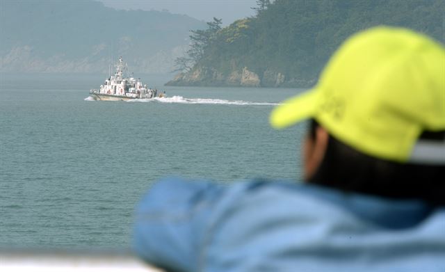 전남 진도군 임회면 팽목항에서 한 자원봉사자가 수색작업 현장으로 출항하는 해경 경비정을 바라보고 있다.한국일보 자료사진