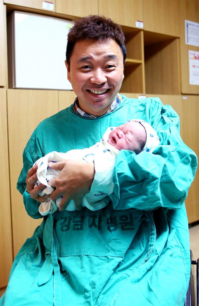 가수 강원래씨가 11일 첫 아기를 안고 활짝 웃고 있다. 연합뉴스