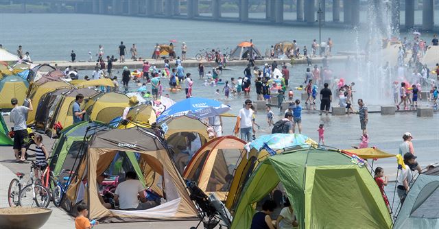 한여름 더위가 이어지고 있는 15일 오후 서울 여의도 한강공원 물빛공원을 찾은 시민들이 더위를 식히고 있다.뉴시스