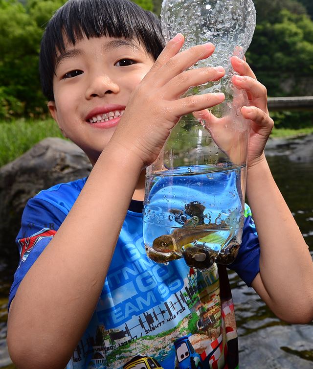 계곡 하류에서 가족과 물놀이하던 어린이가 삼촌이 잡아준 물고기와 다슬기를 자랑하고 있다. 영양=최흥수기자 choissoo@hk.co.kr