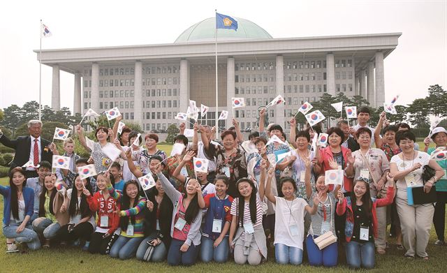 19일 국회 광장에서 고려인 동포들이 '고려인 이주 150주년 기념 모국방문 환영식'을 마친 뒤 태극기를 흔들며 환하게 웃고 있다. 역대 최대인 150명이 찾은 이번 행사에서 이들은 독립기념관과 산업시설 등을 돌아보며 고국의 소중함과 힘을 확인했다. 오대근기자 inliner@hk.co.kr