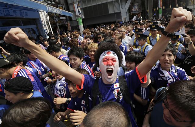 일본 축구팬들이 그리스와의 경기가 끝난 뒤 도쿄 시부야의 상점가에 모여 아쉬움을 달래고 있다. AP연합