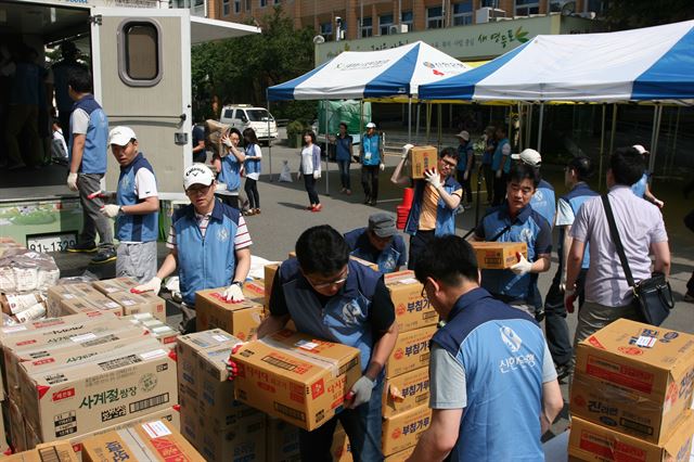 신한금융 직원들이 14일 서울 영등포구청 앞 광장에서 저소득층에게 나눠 줄 식료품을 정리하고 있다.