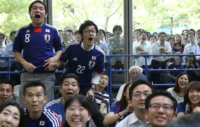 일본과 그리스 경기가 열린 20일(한국시간) 일본 도쿄에서 응원단이 경기를 보며 아쉬워 하고 있다. 도쿄=AP 연합뉴스