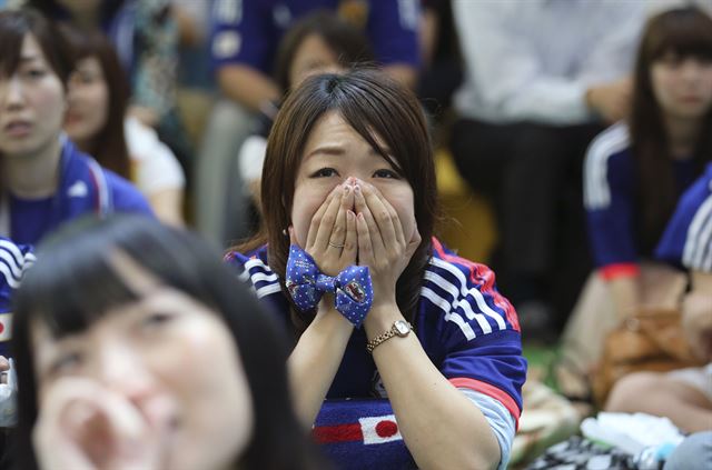 일본과 그리스 경기가 열린 20일(한국시간) 일본 도쿄에서 응원단이 경기를 보며 아쉬워 하고 있다. 도쿄=AP 연합뉴스