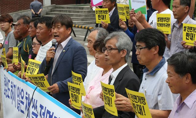 정부가 20일 경기 의왕시 한국농어촌공사 대강당에서 열린 '세계무역기구(WTO) 쌀 관세화 유예 종료 관련 공청회'(위 사진)에서 쌀 시장 전면 개방 입장을 공식화한 가운데 행사장 밖에서 시민단체 회원들이 "협상도 하지 않고 쌀 전면 개방을 선언하는 것은 정부의 역할을 포기하는 행위"라며 시위(아래 사진)를 벌였다. 연합뉴스