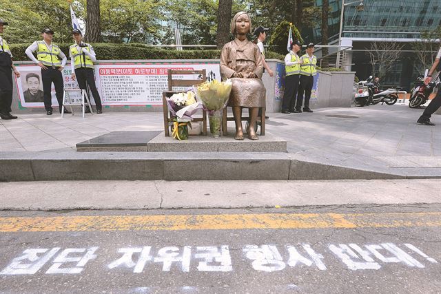 일본 정부가 고노담화 검증 결과를 발표한 20일 서울 중학동 주한일본대사관 맞은편에 세워진 위안부소녀상 앞 도로에 일본의 집단 자위권 행사 시도를 규탄하는 글귀가 새겨져 있다. 뉴시스