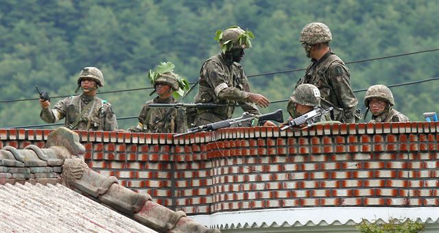 22일 오후 사건 현장과 가장 가까운 것으로 알려진 강원도 고성군 거진읍 명파리 인근에서 교전이 일어나자 무장한 군인들이 민가 옥상 위에서 경계를 서고 있다. 고성=연합뉴스