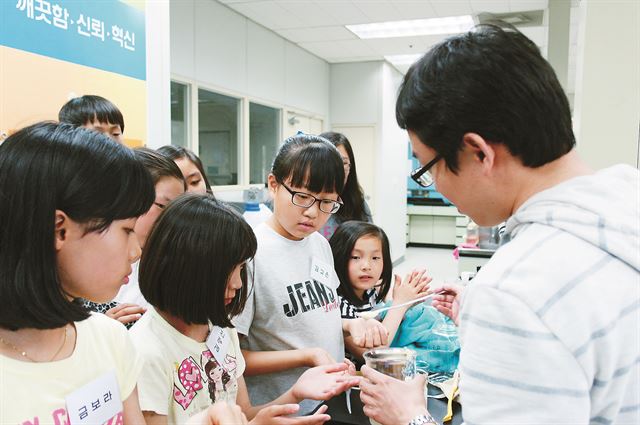 대전 신성동 애경 중앙연구소를 방문한 성심보육원 아이들이 연구원과 함께 과학실험을 하고 있다. 애경 제공