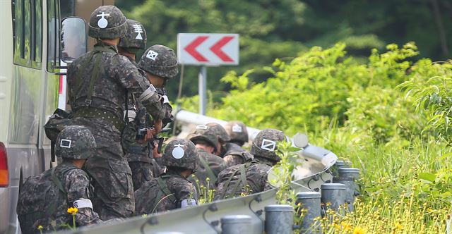 동료 병사들을 살해한 뒤 무장 탈영한 임모 병장 체포작전 이틀째인 23일 오전 강원도 고성군 현내면 명파리와 마달리 사이 도로에서 교전 총성이 들리자 수색팀 장병들이 차량에 엄폐한 채 상황을 지켜보고 있다. 연합뉴스