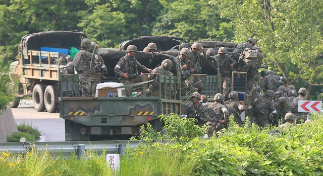 동부전선 GOP에서 동료 병사들을 살해한 뒤 무장탈영한 임모 병장 체포작전 이틀째인 23일 오전 강원도 고성군 거진읍 명파리와 마달리 사이 도로에서 작전에 참가한 703 특공여단 병사들이 부대 전진 방향에서 총소리가 들리자 긴급히 하차해 흩어지고 있다. 연합뉴스