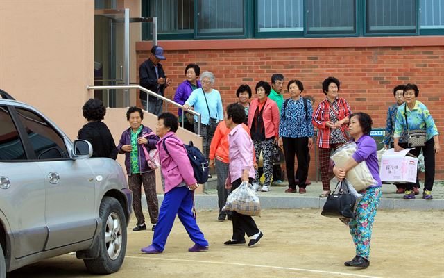 지난 21일 동부전선 GOP에서 발생한 총기 난사 사건으로 인근 대진초등학교 체육관으로 대피해 하룻밤을 보낸 강원 고성군 현내면 명파리 주민들이 23일 오후 집으로 돌아가려고 대피소를 나서고 있다. 주민들의 마을 복귀는 임모 병장의 생포로 상황이 해제된 데 따른 것이다. 연합뉴스