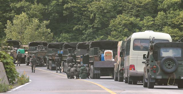 동부전선 GOP에서 동료 병사들을 살해한 뒤 무장탈영한 임모 병장 체포작전 이틀째인 지난 23일 오전 강원도 고성군 거진읍 명파리와 마달리 사이 도로에서 작전에 참가한 수색팀이 부대 전진 방향에서 교전의 총성이 들리자 차량 뒤에 엄폐한 뒤 경계하고 있다. 연합뉴스