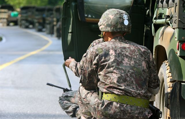 동부전선 GOP에서 동료 병사들을 살해한 뒤 무장탈영한 임모 병장 체포작전 이틀째인 23일 오전 강원도 고성군 거진읍 명파리와 마달리 사이 도로에서 작전에 참가한 병력들이 부대 전진 방향에서 교전의 총성이 들리자 차문을 이용해 엄폐한 뒤 상황을 살피고 있다. 연합뉴스