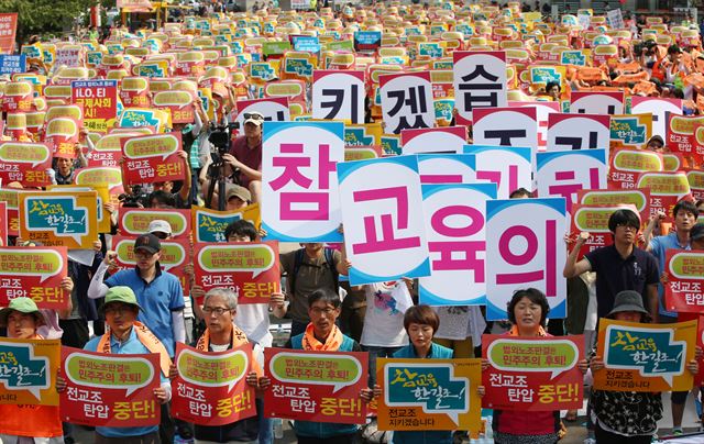 27일 오후 서울 봉래동 서울역광장에서 열린 전교조 전국교사대회에서 참석 조합원들이 피켓을 든 채 구호를 외치고 있다. 연합뉴스