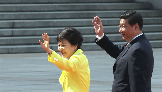 박근혜 대통령과 시진핑 중국 국가주석이 27일 인민대회당 광장에서 열린 공식환영식에서 의장대를 사열한 뒤 환영객들에게 손을 들어 인사하고 있다. 연합뉴스