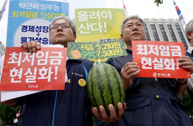 26일 오전 정부서울청사 앞에서 열린 최저임금 현실화 촉구 양대 노총 위원장 기자회견에서 신승철 민주노총 위원장(왼쪽)과 김동만 한국노총 위원장이 '최저임금 현실화!'라고 적힌 손팻말을 들고 있다. 김주성기자 poem@hk.co.kr