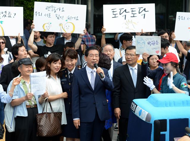 박원순 서울시장이 1일 오전 서울시청 정문 앞에서 취임식을 마친 후 직접 마이크를 잡고 시청 안내를 시작하고 있다. 홍인기기자 hongik@hk.co.kr