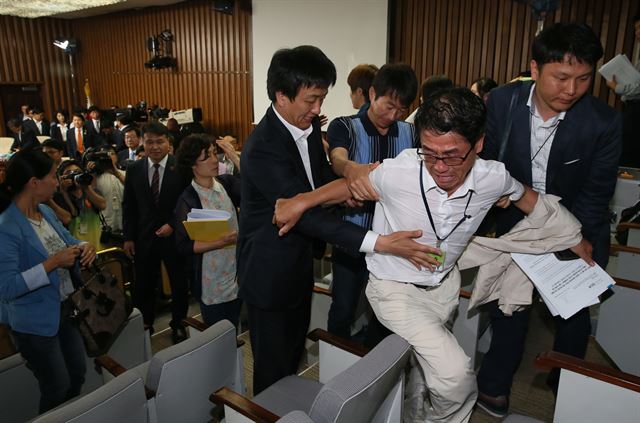 2일 국회에서 열린 세월호침몰사고 진상규명을 위한 국정조사특별위원회 해양경찰청 소관 기관보고에서 오전회의가 정회된 뒤 세월호 가족대책위원들 중 한 사람이 의원들에게 울먹이며 항의하자 가족대책위 동료들이 만류하고 있다. 연합뉴스