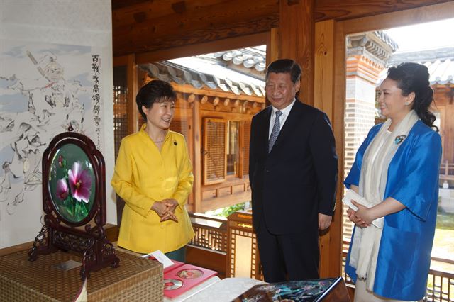 박근혜 대통령이 4일 서울 성북동 한국가구박물관에서 시진핑 중국 국가주석 부부와 특별 오찬을 한 뒤 족자와 공예품 등 시 주석의 선물을 받고 활짝 웃고 있다. 청와대 제공