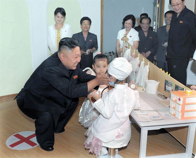 북한에서도 유치원생 선행학습이 사회문제가 되고 있는 것으로 보인다. 사진은 2012년 김정은 북한 국방위원회 제1위원장이 평양 경상유치원에서 20대로 보이는 젊은 여성(뒷줄 맨 왼쪽)이 지켜보는 가운데 한 어린이를 어루만지는 모습. 한국일보 DB