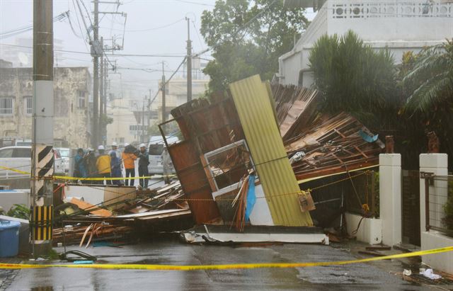 8호 태풍 너구리가 8일 일본 남부 오키나와를 강타한 가운데 오키나와현의 주요 도시 중 하나인 나하시에서 목조 건물이 강풍으로 붕괴되어 있다. 이날 오키나와현 일대에는 21만 세대, 50만 명에게 피난 권고령이 내려졌다. 나하=AFP 연합뉴스