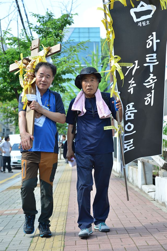 8일 오후 경기 안산 단원고 앞에서 세월호 희생자 학부모들이 십자가를 메고 진도 팽목항과 프란치스코 교황이 방한해 미사를 갖는 대전월드컵경기장까지 800Km, 1900리 길을 도보로 행진하는 대장정에 나서고 있다. 도보행진에 나선 희생자 학부모들은 세월호 참사를 잊지 않고 11명의 실종자 무사귀환 기원, 철저한 진상규명과 특별법 제정 촉구 등을 위해 마련했다고 밝혔다. 뉴시스