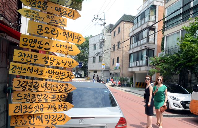 10일 이태원 거리를 찾은 시민들이 맛집을 찾기 위해 골목 초입에 세워진 이정표를 확인하고 있다. 신상순선임기자ssshin@hk.co.kr