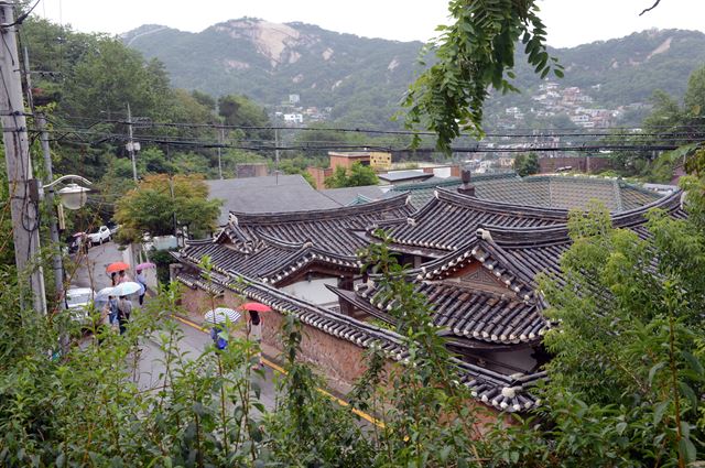 서울 부암동의 좁고 굽어진 오르막길은 비가 와도 사람들로 붐빈다. 사람들은 키 작은 건물의 기와에 쌓인 세월의 흔적과 고즈넉함에 기대 서울 도심의 분주함을 떨쳐 낸다. 신상순 선임기자 ssshin@hk.co.kr