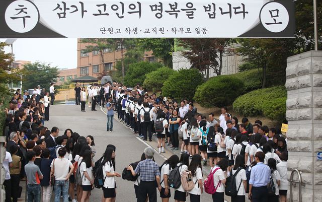 지난달 25일 오전 경기도 안산시 단원구 단원고등학교에서 2학년 학생들이 세월호 희생 학생들의 부모님에게 인사를 드리며 71일만에 등교하고 있다. 연합뉴스